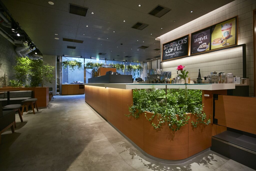 カウンターに植栽を組み込み、照明計画で屋内でも緑を育てるスターバックス コーヒー 表参道ヒルズ店の店内